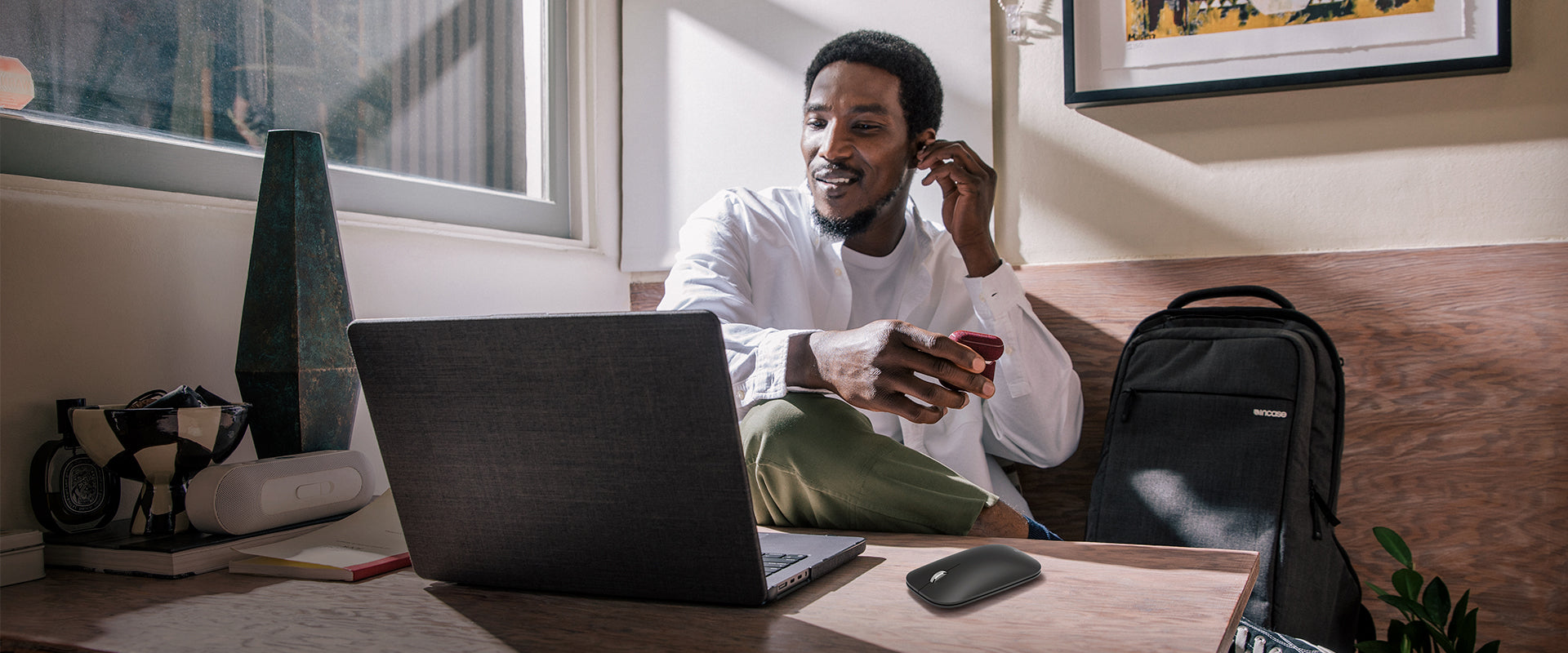 photo of a person at a desk with their laptop, ICON backpack, and Incase Designed By Microsoft accessories