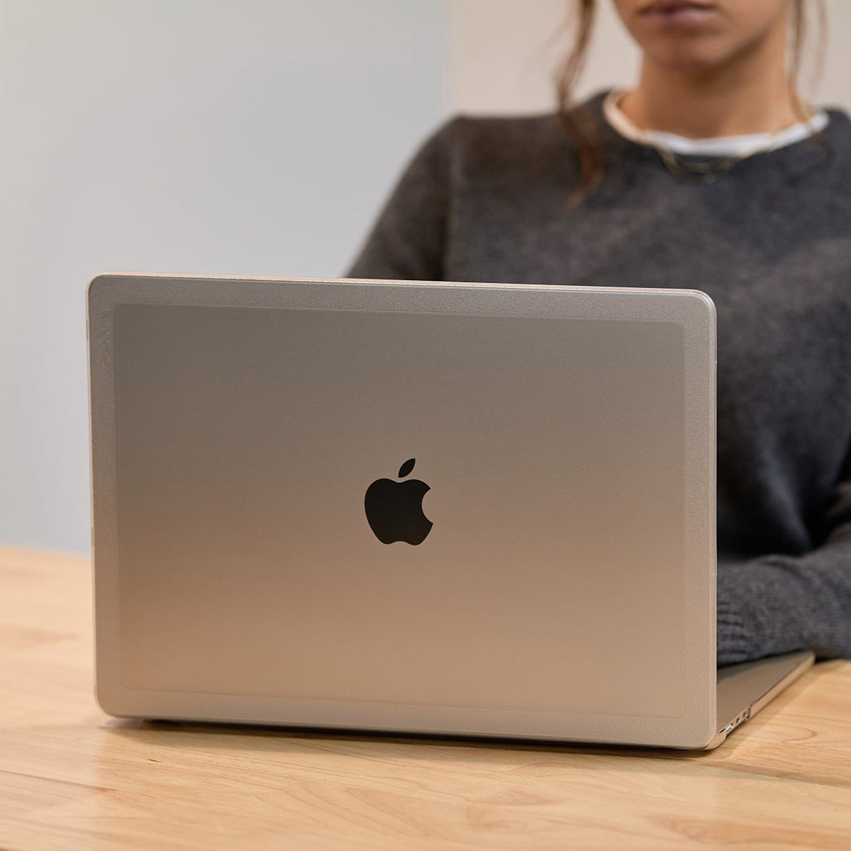 person sitting at a desk using a macbook protected by the edge hardshell