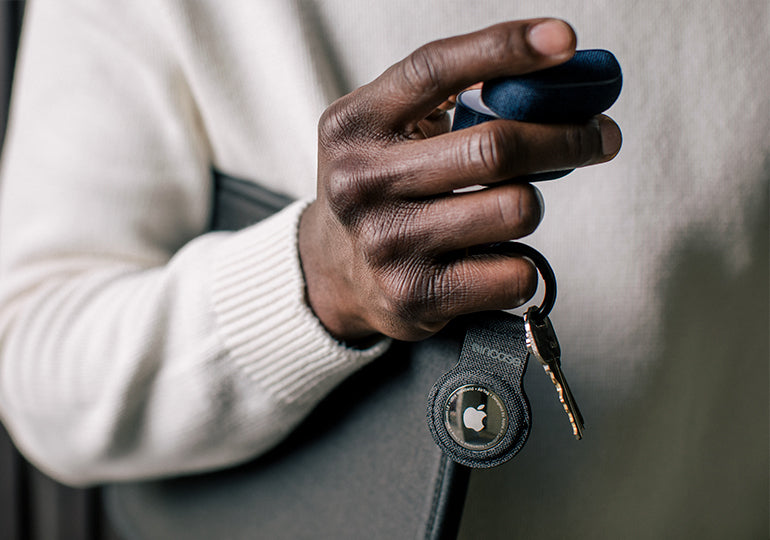 Person holding Incase Woolenex AirTag Keyclip and Woolenex AirPods Case