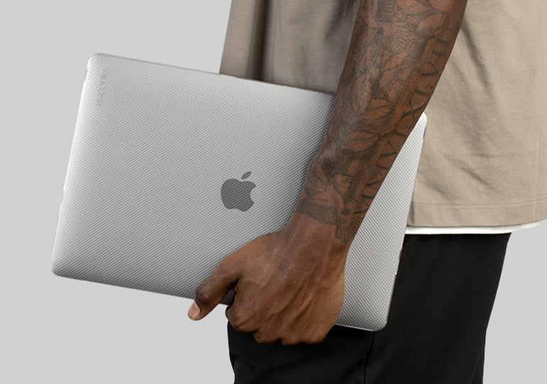 Person holding a MacBook Pro with a Clear Hardshell Dots case