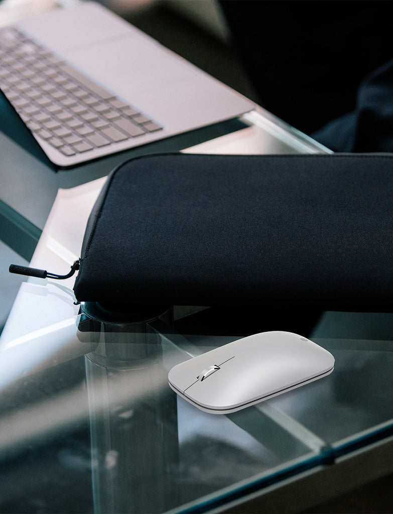 photo of Incase designed by microsoft mouse laying on a glass table